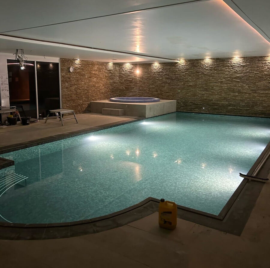 Hot tub with blue tile detail and large swimming pool