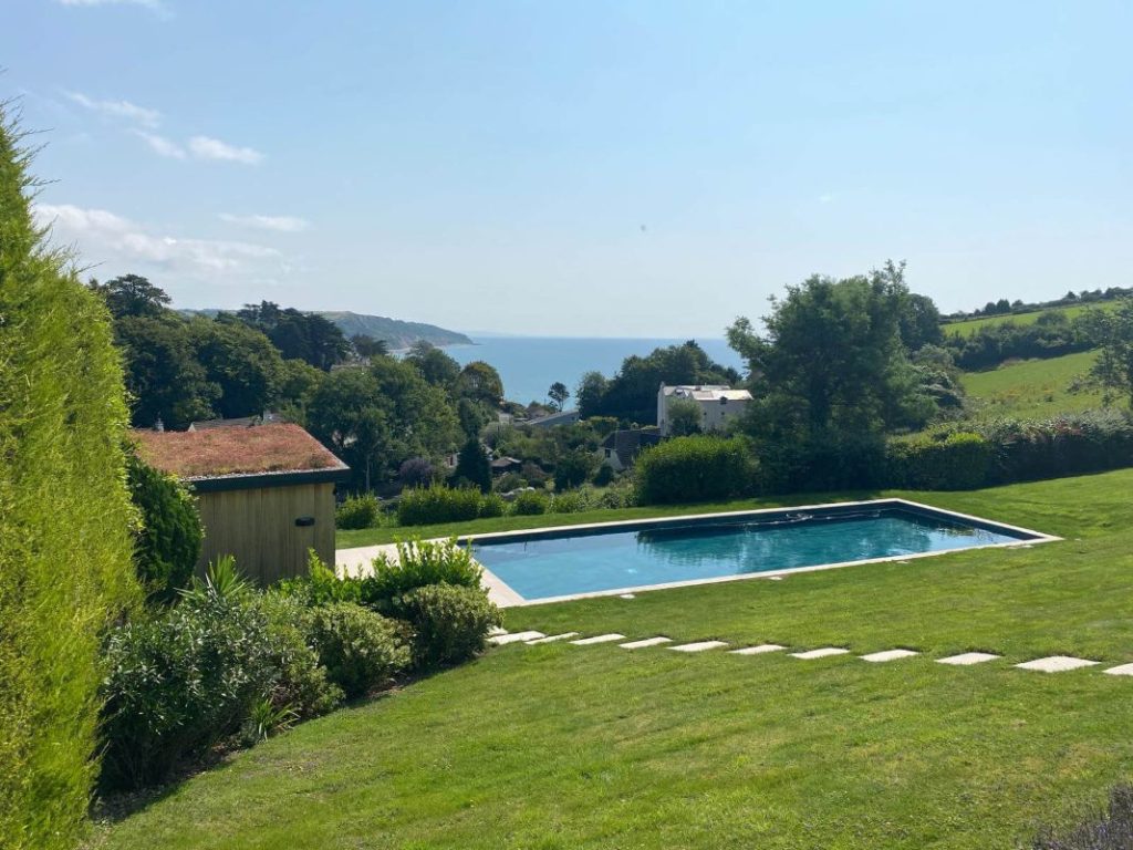 Luxurious infinity pool overlooking the serene coastline and green hills of Devon, UK. Perfect for relaxation and scenic views