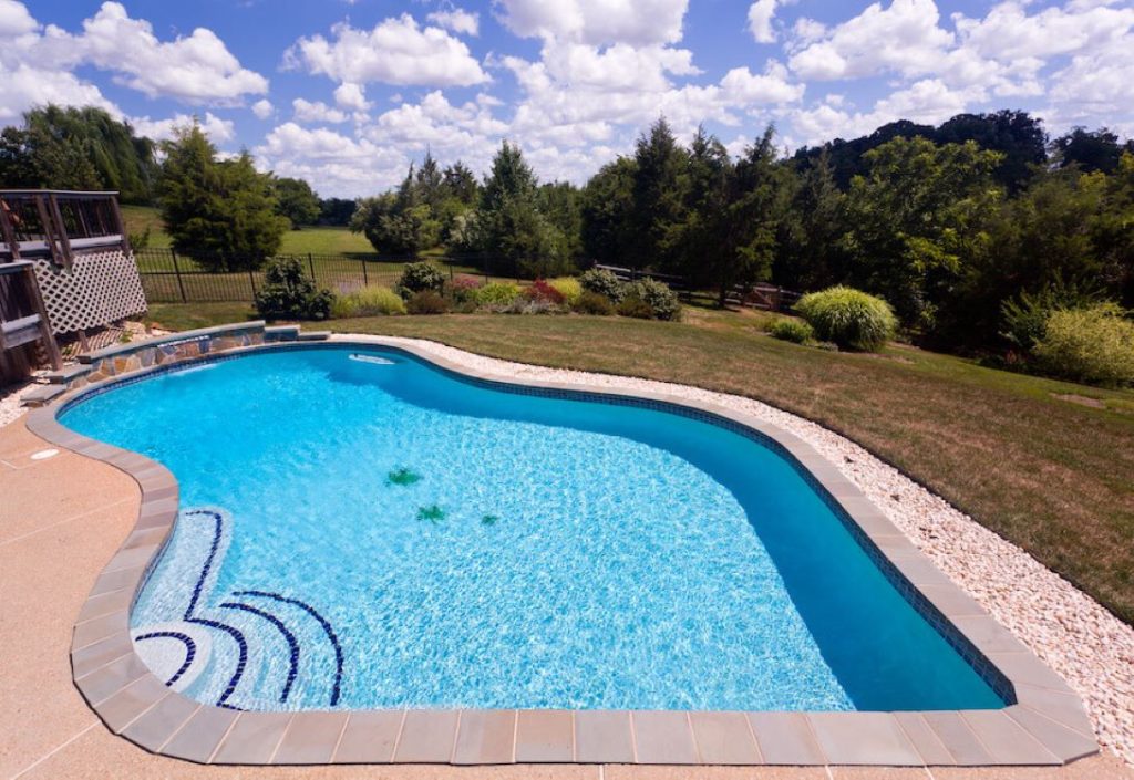stock image of a swimming pool in a large back garden after being cleaned